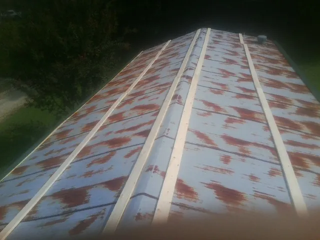 Rusted metal roof panels with new wood purlins before replacement — Storm Damage Roof Repair in Boxborough by Roofing Brothers