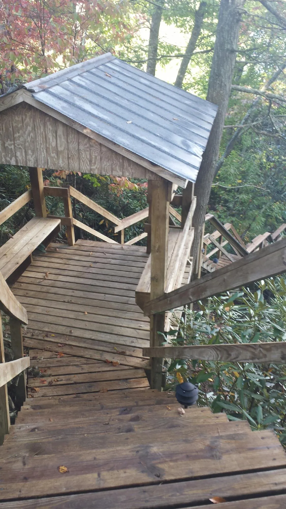 Metal roofed shelter over wooden steps on a wooded walkway — Skylight Repair & Installation work by our crew in Boxborough