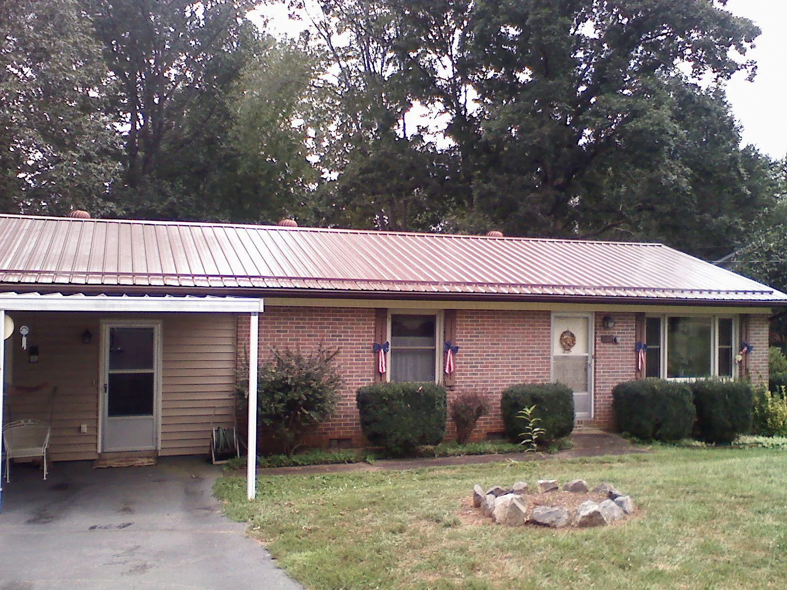 Bronze metal roof and carport on a brick ranch home — Roof Repair work by our crew in Boxborough